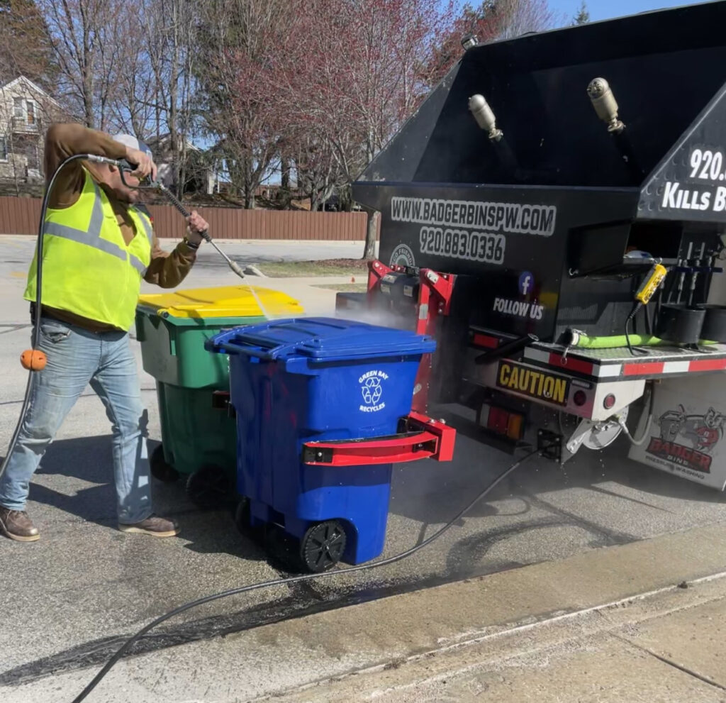 worker cleaning trash bins